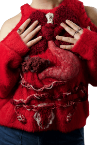 a woman wearing a red sweater with her hands on her stomach